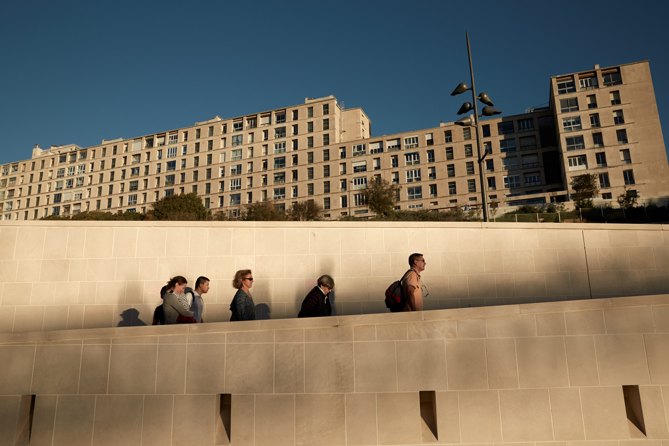 people walking along a wall in Marseille, France