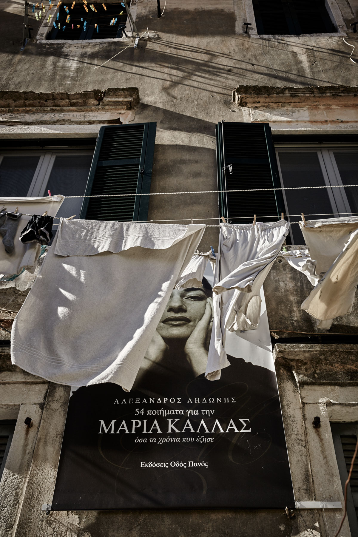 poster of Maria Callas on a wall with laundry in Corfu