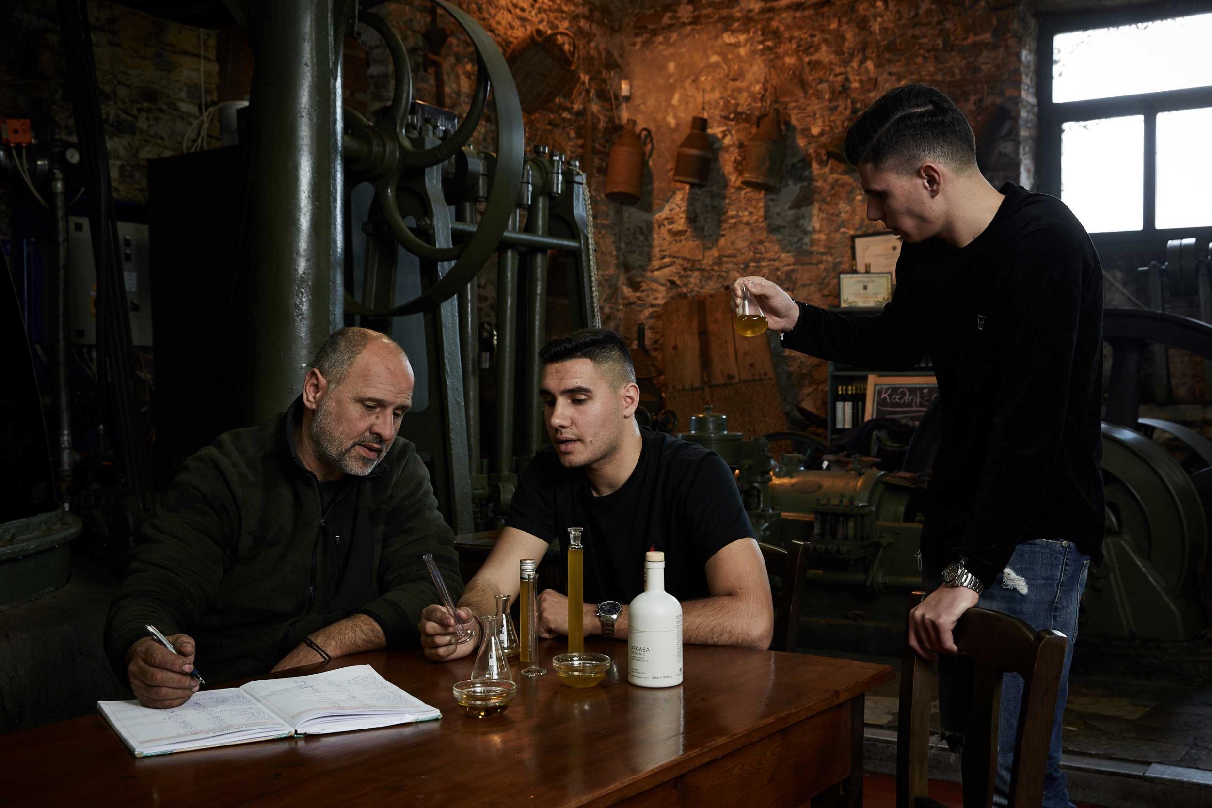 Kostas Protoulis and sons examing the quality of olive oil 