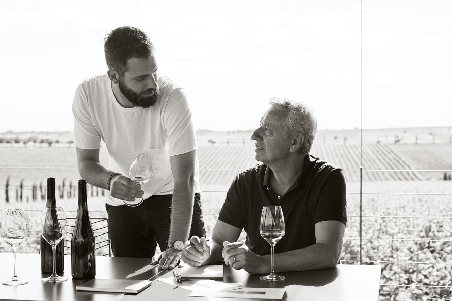 Vaggelis Gerovassiliou and son tasting wine in front of vinyard