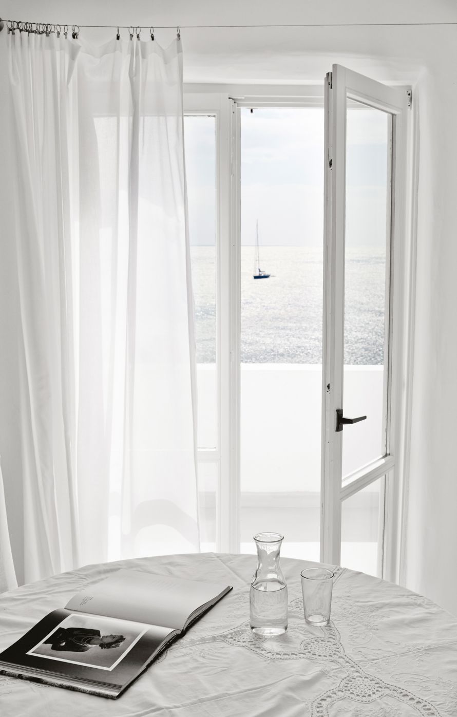 Grecotel Mykonos Blu , table in front of window with book and water bottle