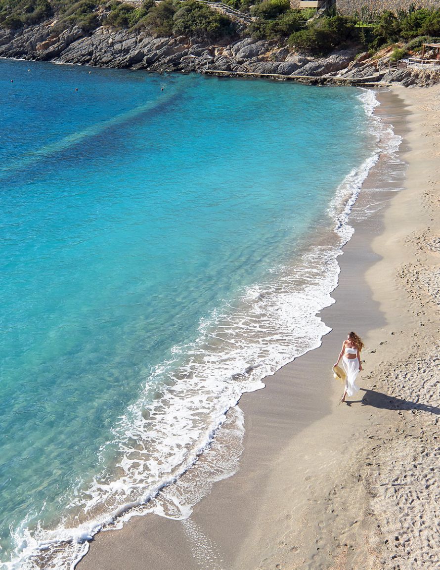 Daios Cove aerial view of beach with woman walking along the beach