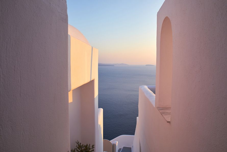 La Perla Santorini, Greece, stairs, pink walls, warm light